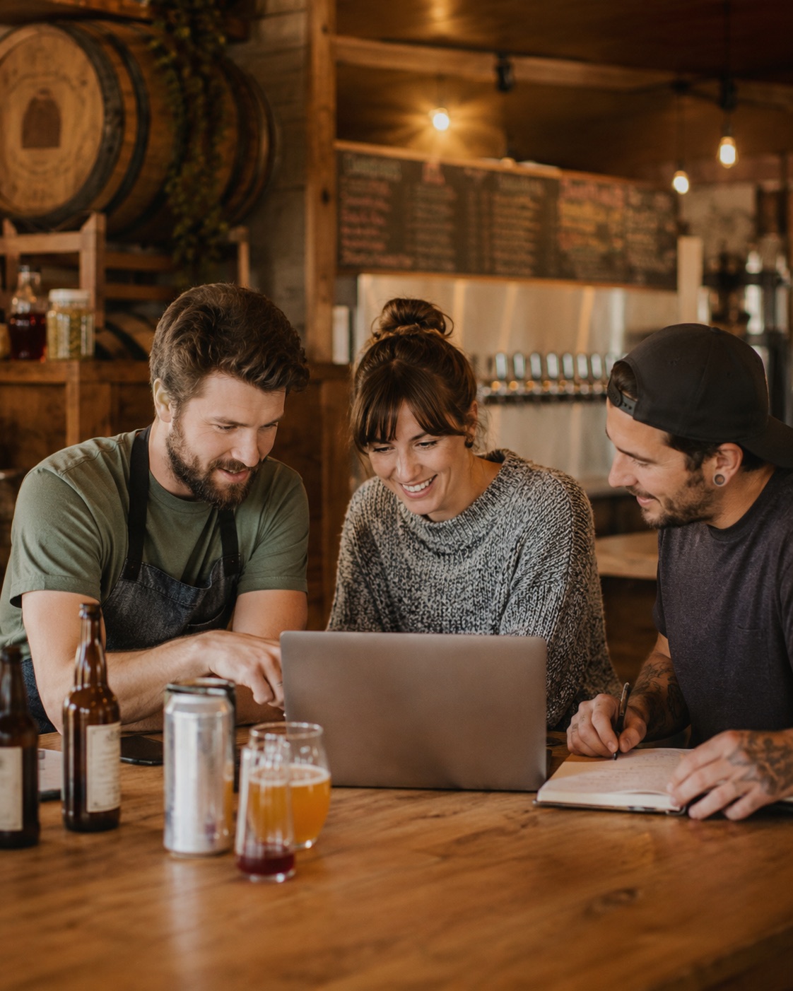 Craft beverage operators reviewing production, tasting room sales, and cash flow around a laptop